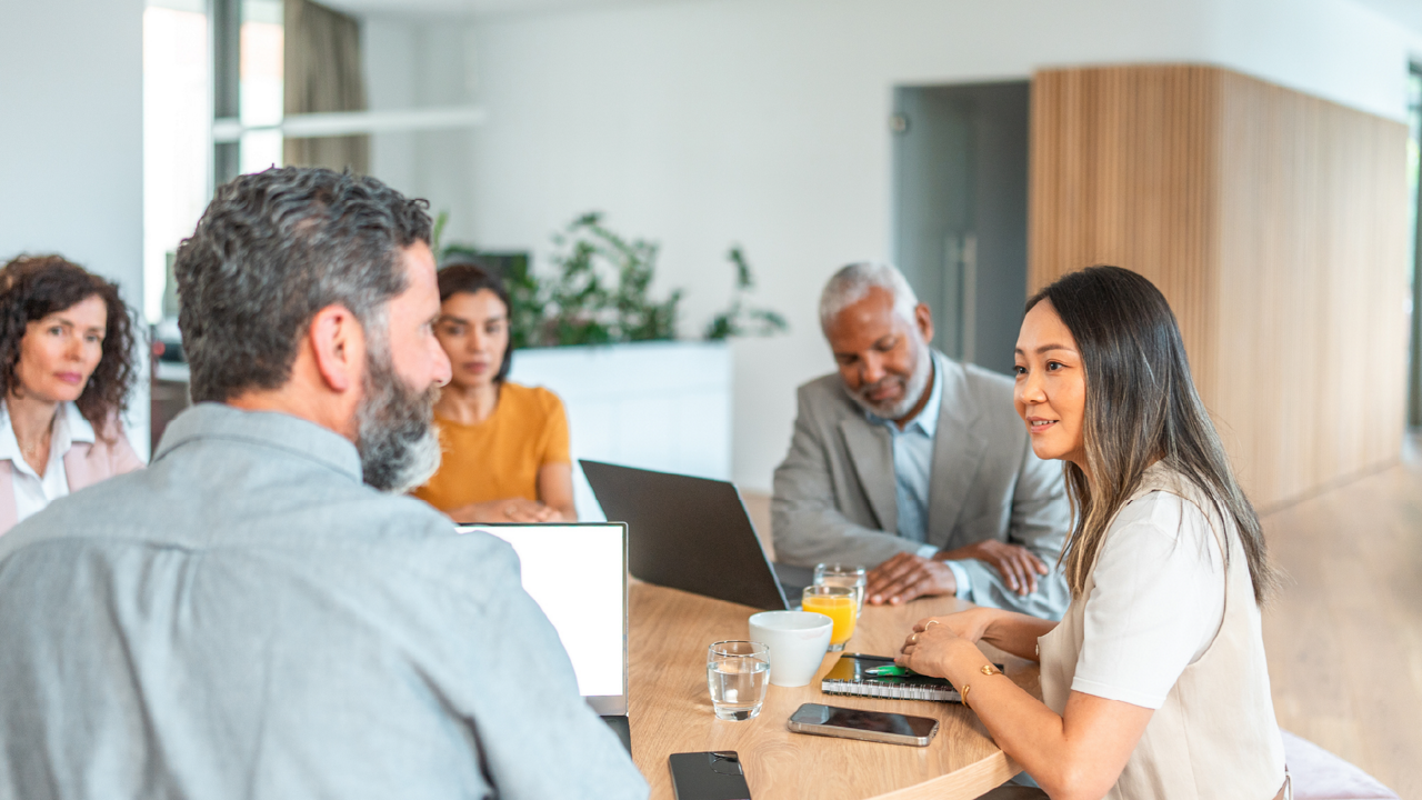 Group of people sitting around a table in an office environment